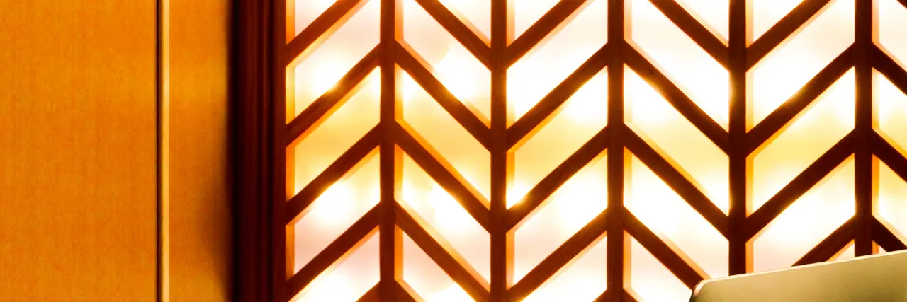 A lit wooden lattice screen at the entrance